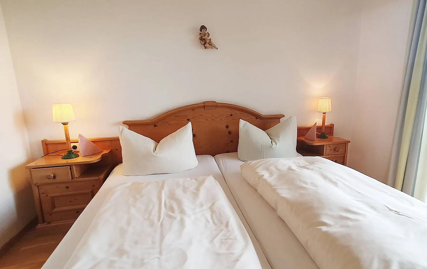 Doppelzimmer mit Holzbett und Nachttischlampen