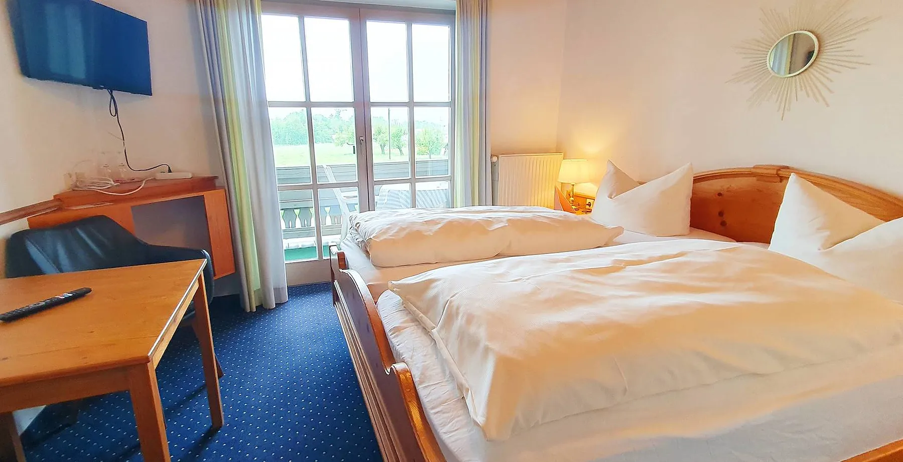 Zimmer mit Schreibtisch und Fenstertür